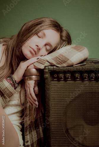 A beautiful teenage girl sleeping on a sound device