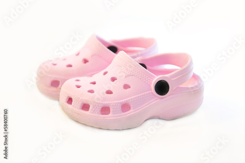 Baby pink rubber summer shoes on white.