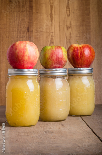 Foto Jars of homemade applesauce with apples