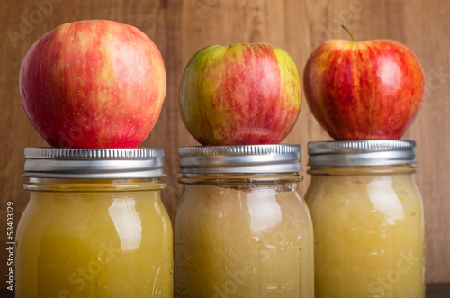 Jars of homemade applesauce with apples photo