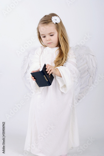 A beautiful little girl angel with a book