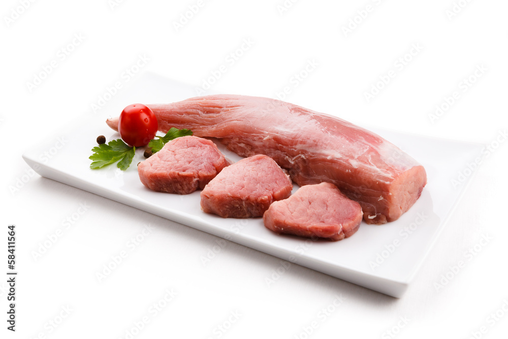 Raw pork loin and vegetables on white background