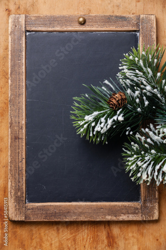 Vintage slate chalk board with Fir branch on wooden background