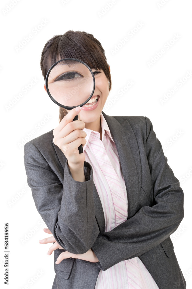 Young asian woman looking through a magnifying glass Young asian woman looking through a magnifying glass