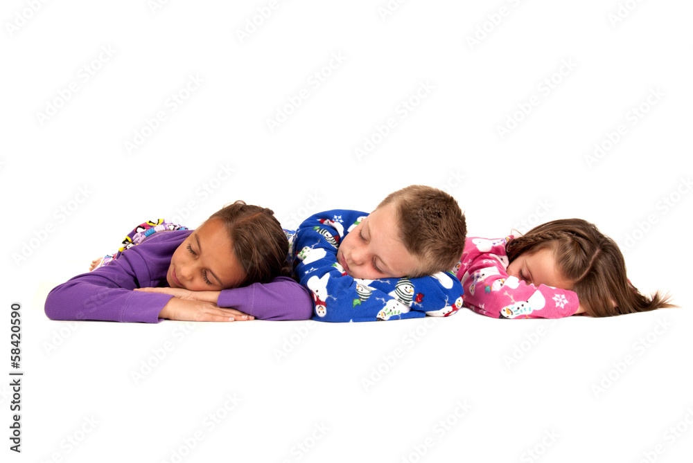 Three children laying down in their warm winter pajamas Three children laying down in their warm winter pajamas
