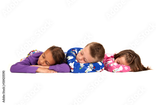 Three children laying down in their warm winter pajamas