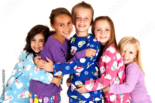 happy children in winter pajamas hugging each other photo