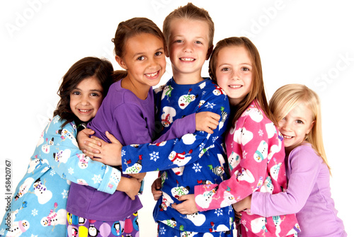 happy children in winter pajamas hugging each other