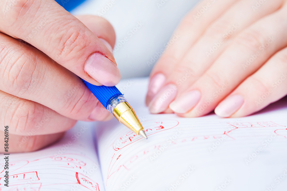 Business Woman Writing with pen in notepad Business Woman Writing with pen in notepad