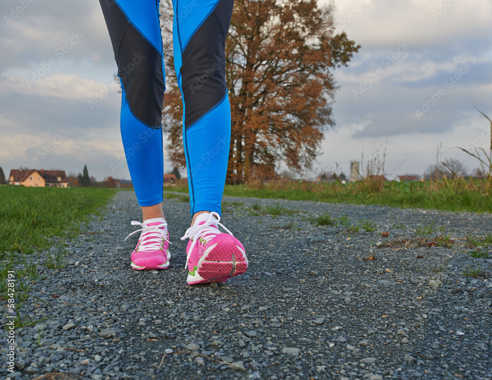Sporty female walking and running on a road Stock Photo | Adobe Stock