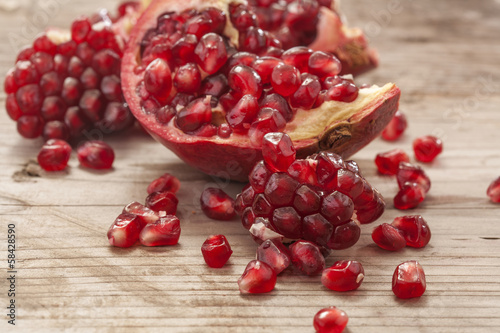 Foto Fresh and juicy pomegranate fruit on wood