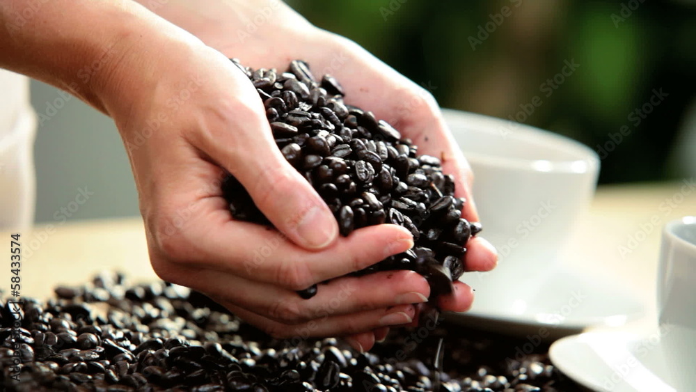 Fresh Coffee Beans Pouring Onto White Table Female Hands