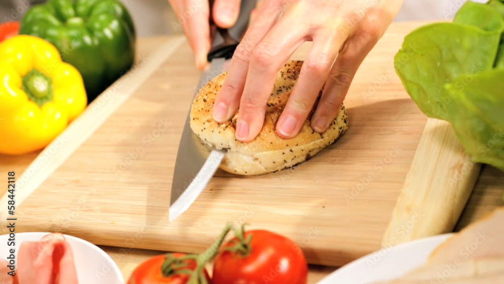 Female Hands Slicing Fresh Granary Bagel
