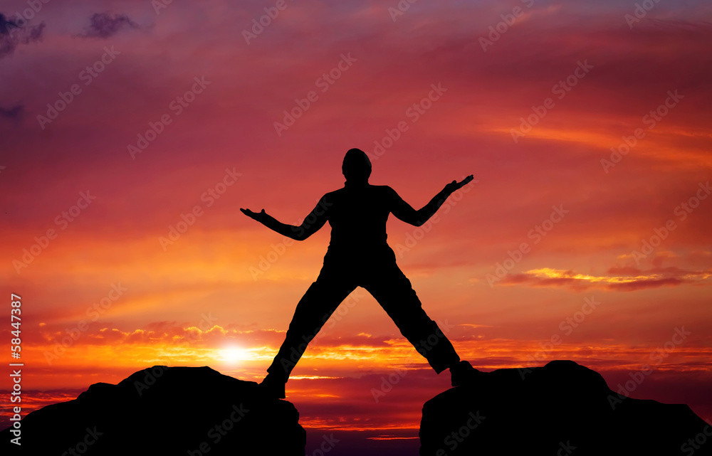 Silhouette of man on sunset fiery sky background