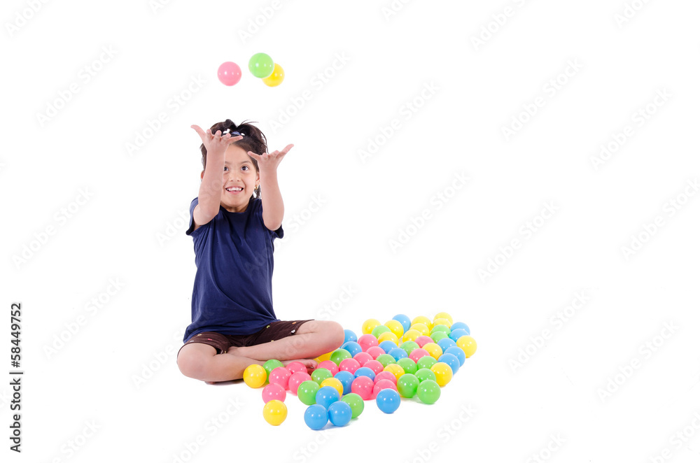 Fototapeta premium Happy little girl playing with colourful balls