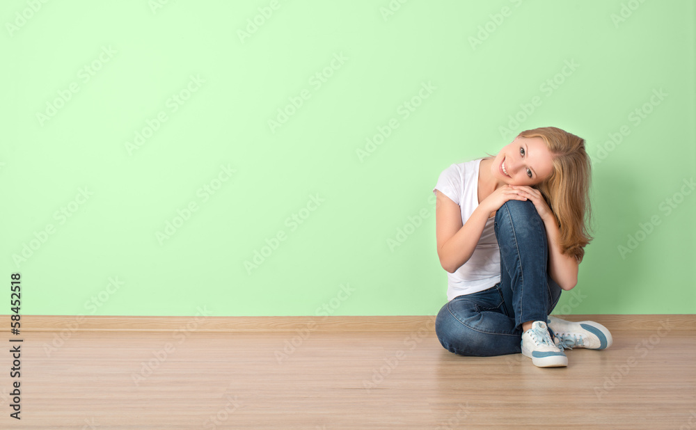 happy  woman is sitting in a room with a blank wall