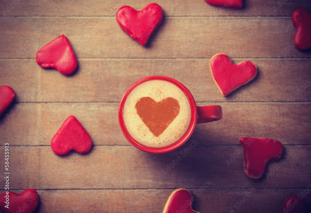 Fototapeta premium Cup of coffee with heart symbol and candy around.