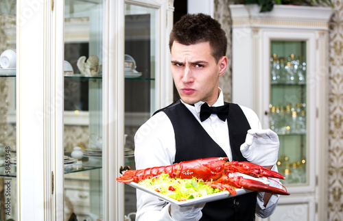 waiter with lobster on a plate in a restaurant
