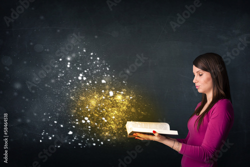 Young lady reading a magical book