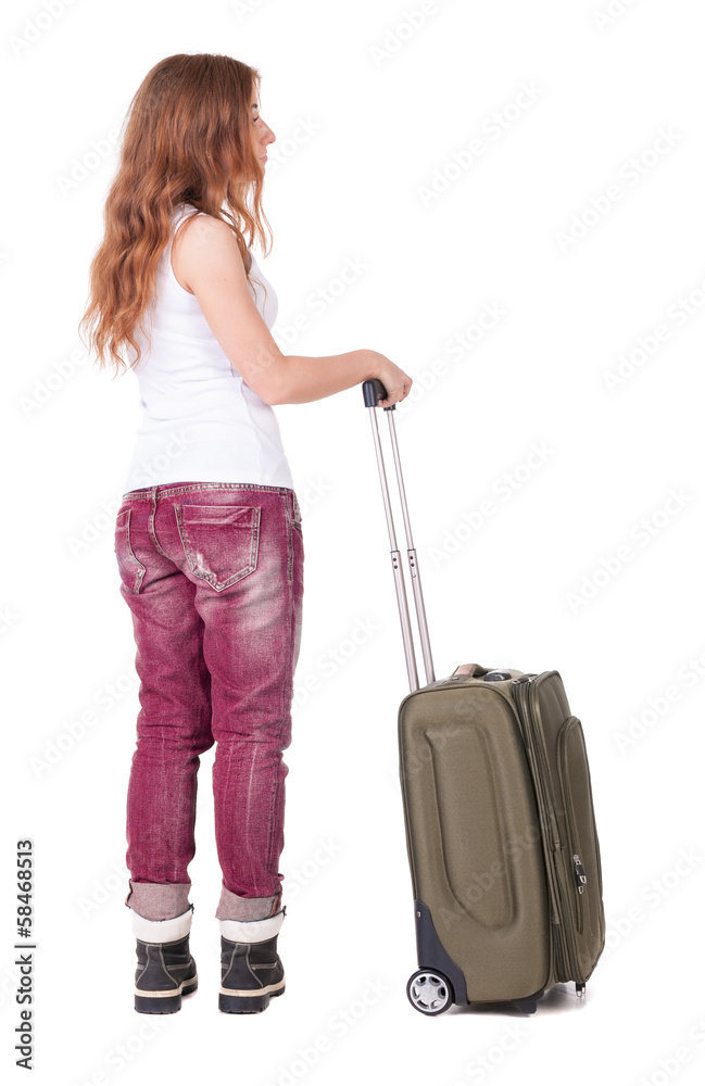 Back view of stylishly dressed woman with suitcase looking up Back view of stylishly dressed woman with suitcase looking up