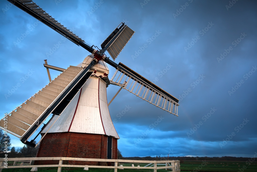 white Dutch windmill in sunset light