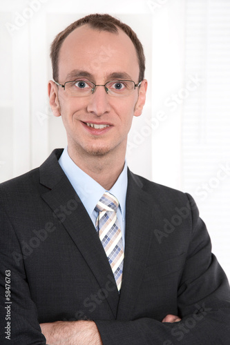 Caucasian manager with glasses in suit and tie.