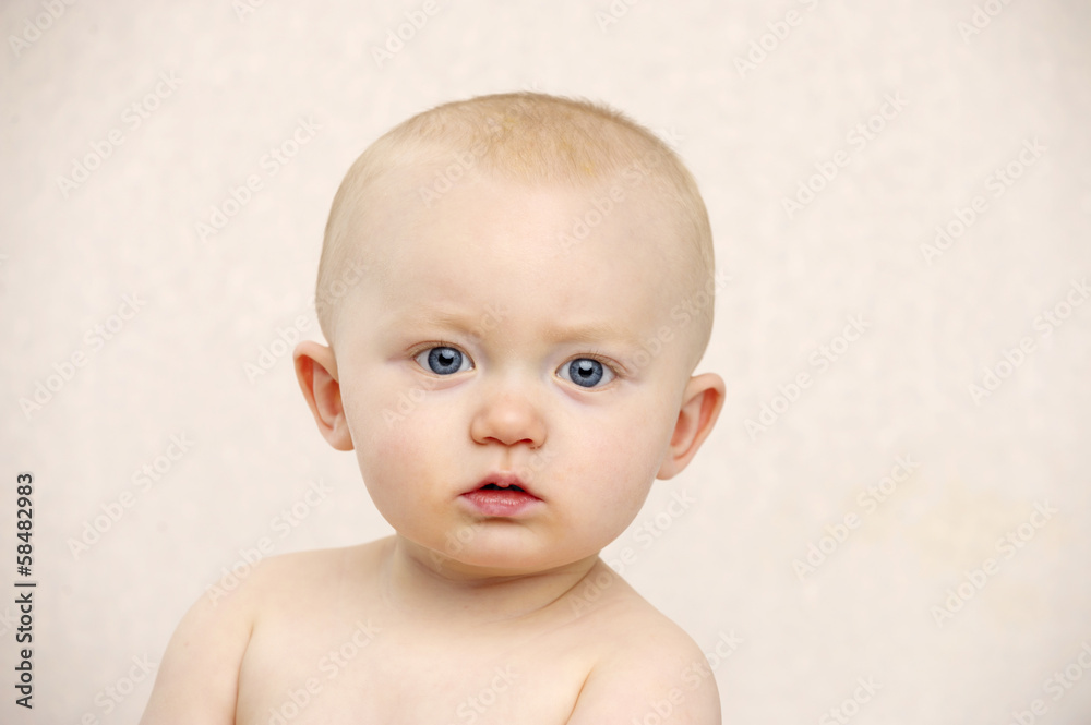Baby looking at the camera on a peach background Baby looking at the camera on a peach background