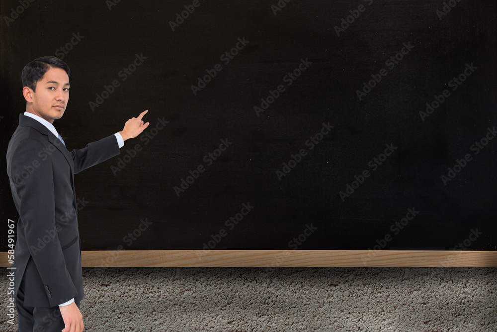 Composite image of serious asian businessman pointing Composite image of serious asian businessman pointing
