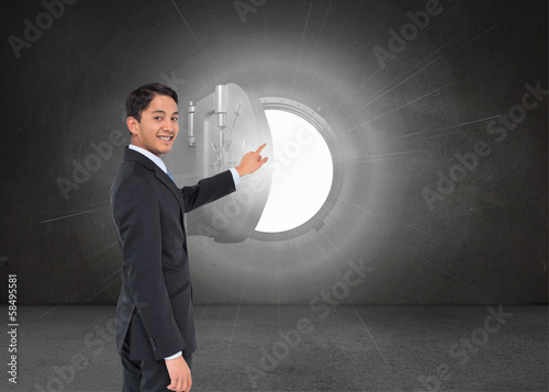 Composite image of smiling asian businessman pointing