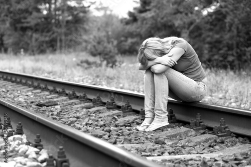 upset girl sitting on the rails