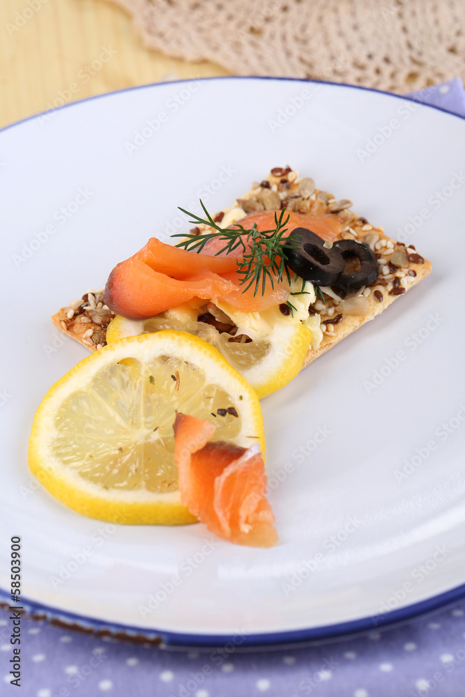 Salmon sandwich on plate  on wooden table close-up