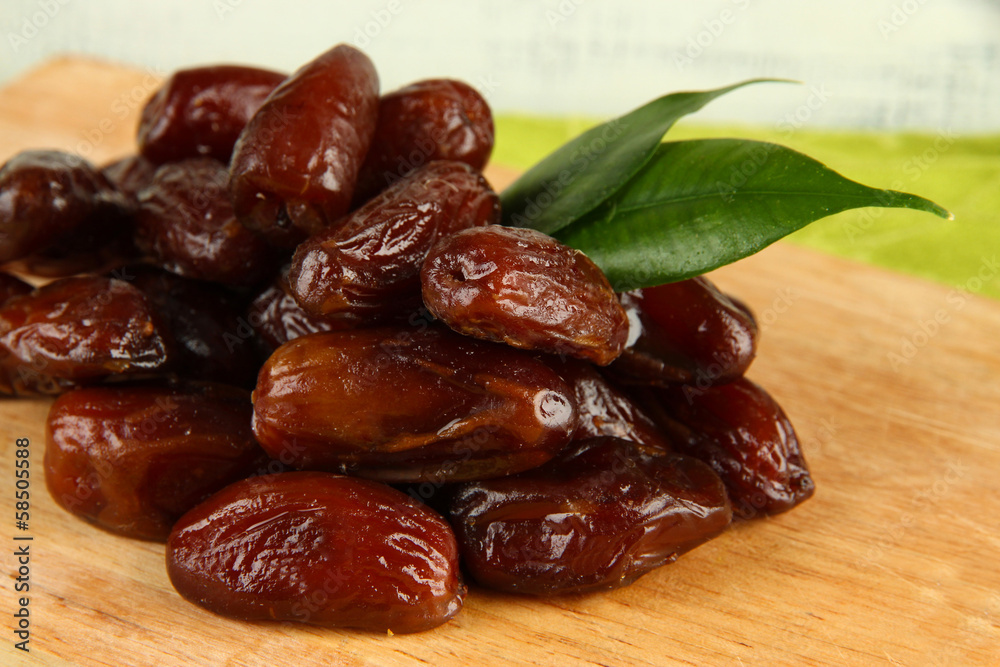 Dried dates on wooden stand on table on wooden background Dried dates on wooden stand on table on wooden background