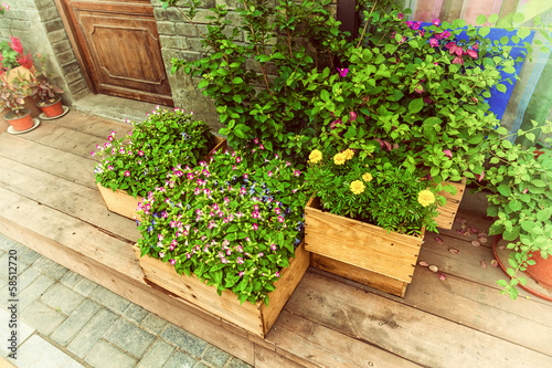 Flowers in wooden pot at the store entrance