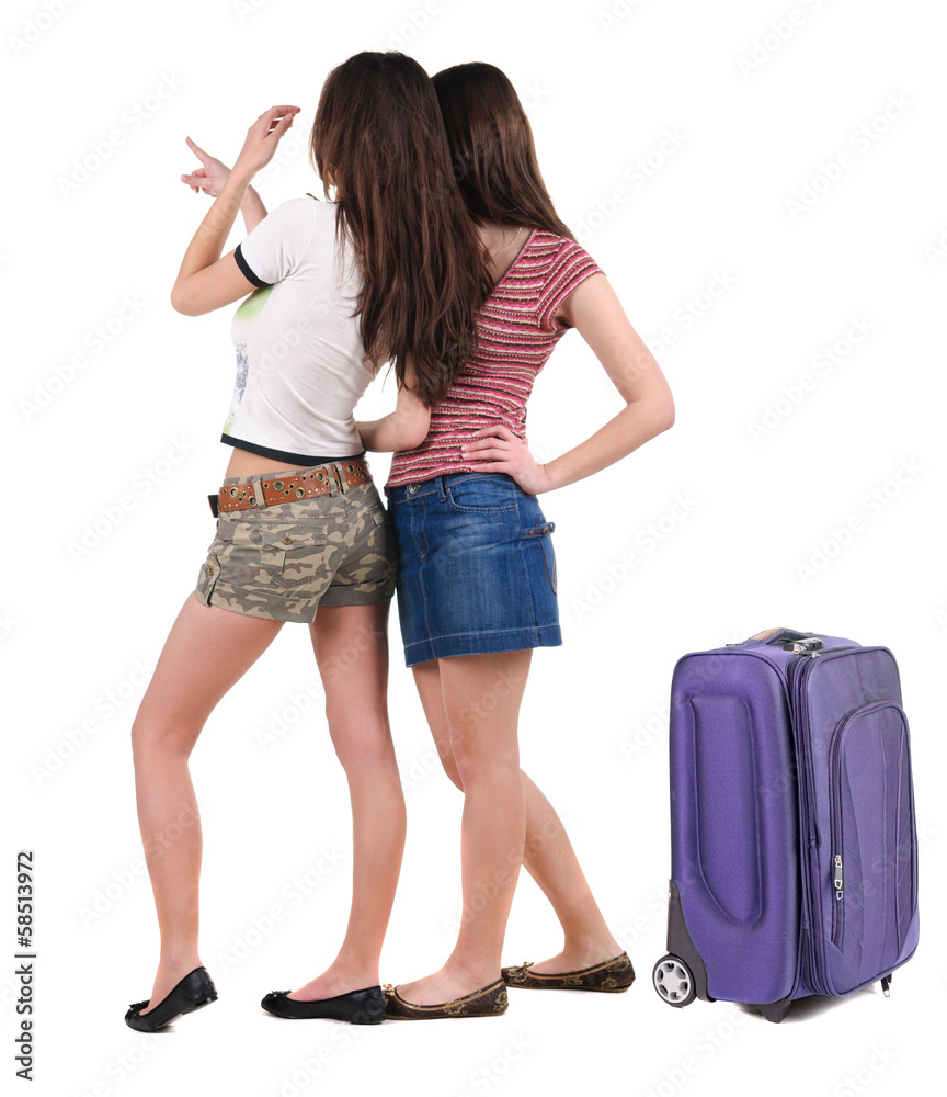 Two young women traveling with suitcas rear view. Two young women traveling with suitcas rear view.