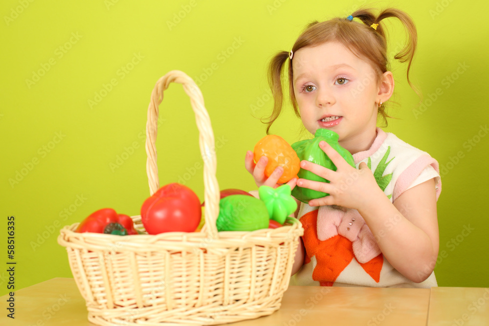 A girl with pigtails playing with plastic vegetables A girl with pigtails playing with plastic vegetables