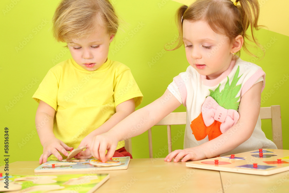 Little boy and girl with pigtails playing a board game Little boy and girl with pigtails playing a board game