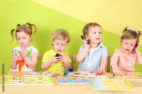 Two boys and two girls with phones in their hands