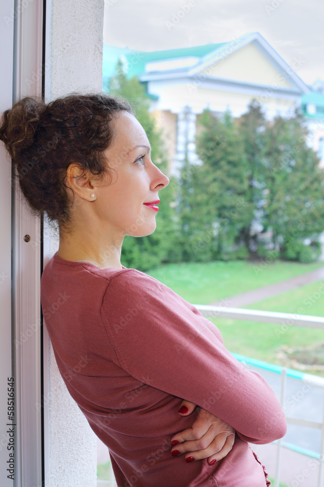 A young woman is standing on the balcony A young woman is standing on the balcony