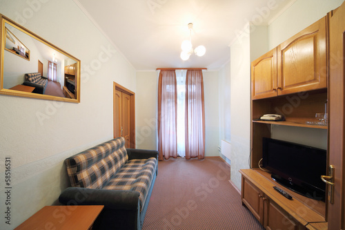 Small living room with checkered sofa and wall cabinet