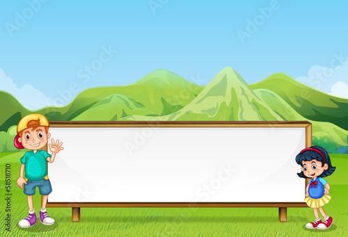 A young boy and a young girl beside the empty signboard