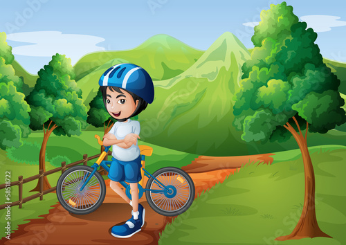 A boy standing in the middle of the pathway with his bike