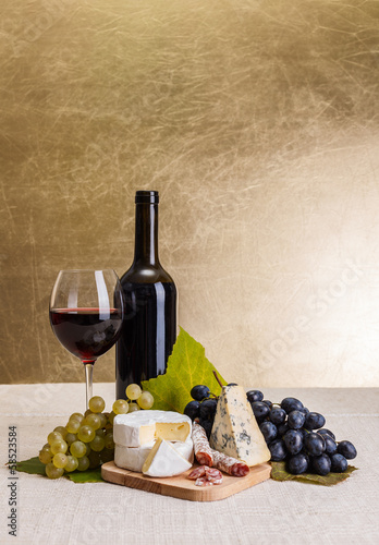 Fototapeta Naklejka Na Ścianę i Meble -  Red wine with cheese and blue grape snack