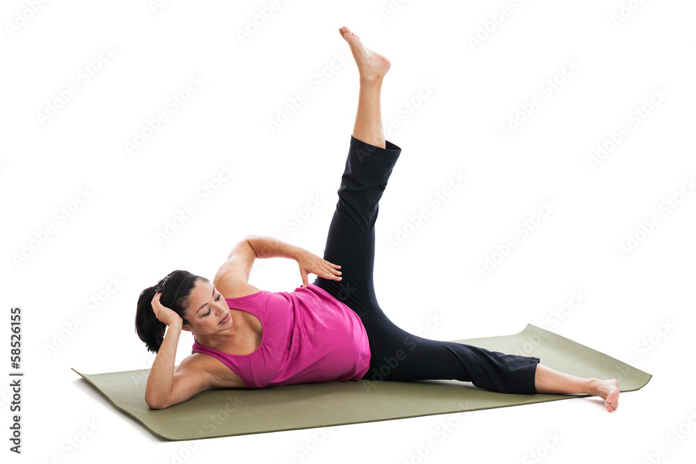Pregnant woman doing leg extensions on exercise mat Pregnant woman doing leg extensions on exercise mat