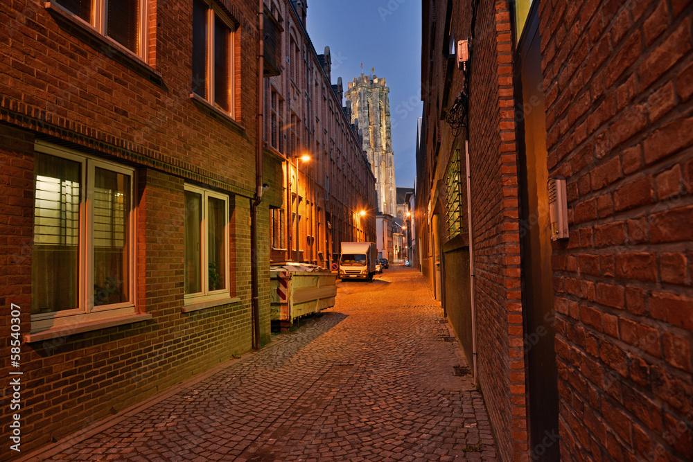 Street with church in the background at dusk. Sint-Rombout cathe Street with church in the background at dusk. Sint-Rombout cathe