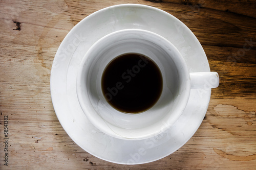 Coffee cup over wood table background. Dregs in the bottom of th