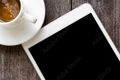 digital white tablet and coffee cup on wooden table