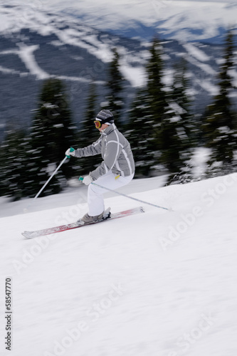 A young female skier enjoying downhill skiing in British Columbi photo