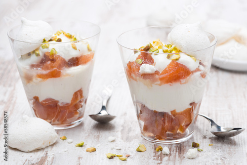 dessert with canned peaches, whipped cream and meringue in glass