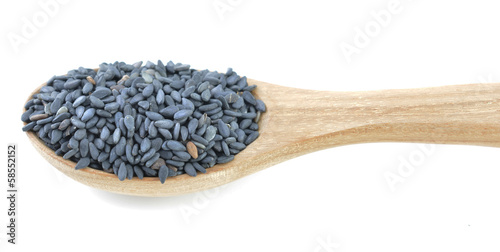 Wooden spoon with sesame seeds on a white background