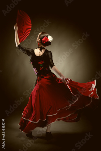 young woman dancing flamenco on black photo